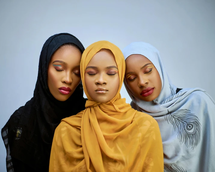 three mannequins one wearing a hijab and one with two veils around