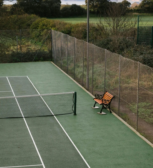 a tennis court with a bench and net