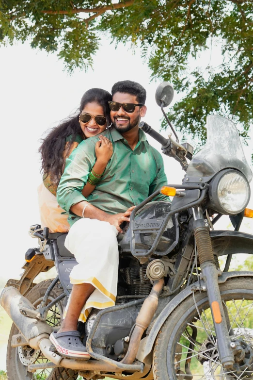 a couple is posing on a motorcycle