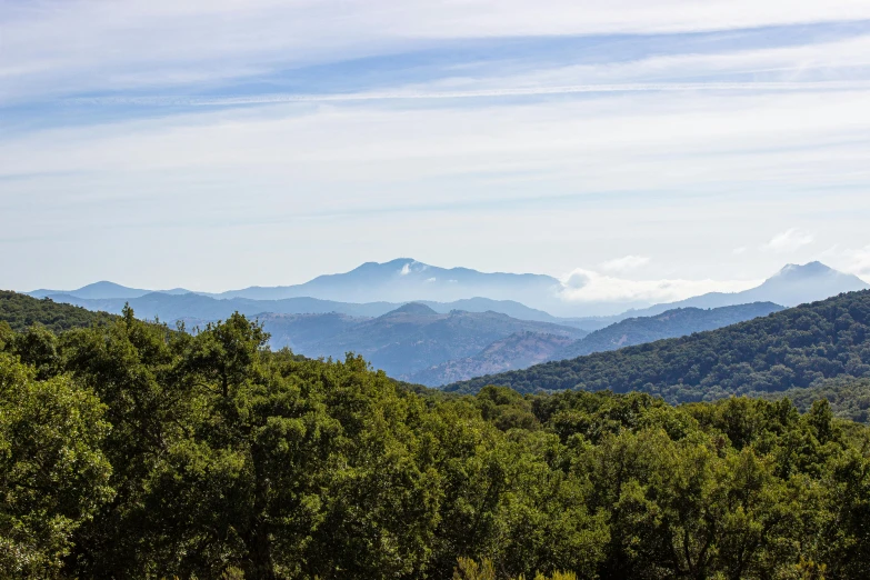 a view of mountains, the clouds and trees