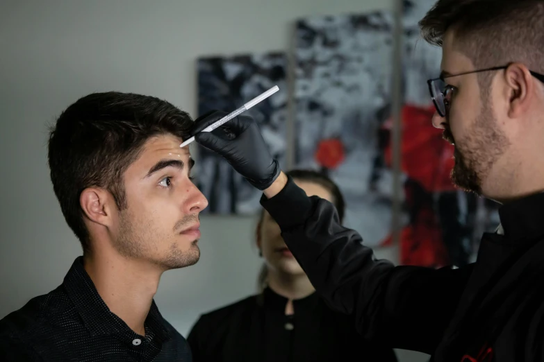 a man standing next to a barber holding a scissors