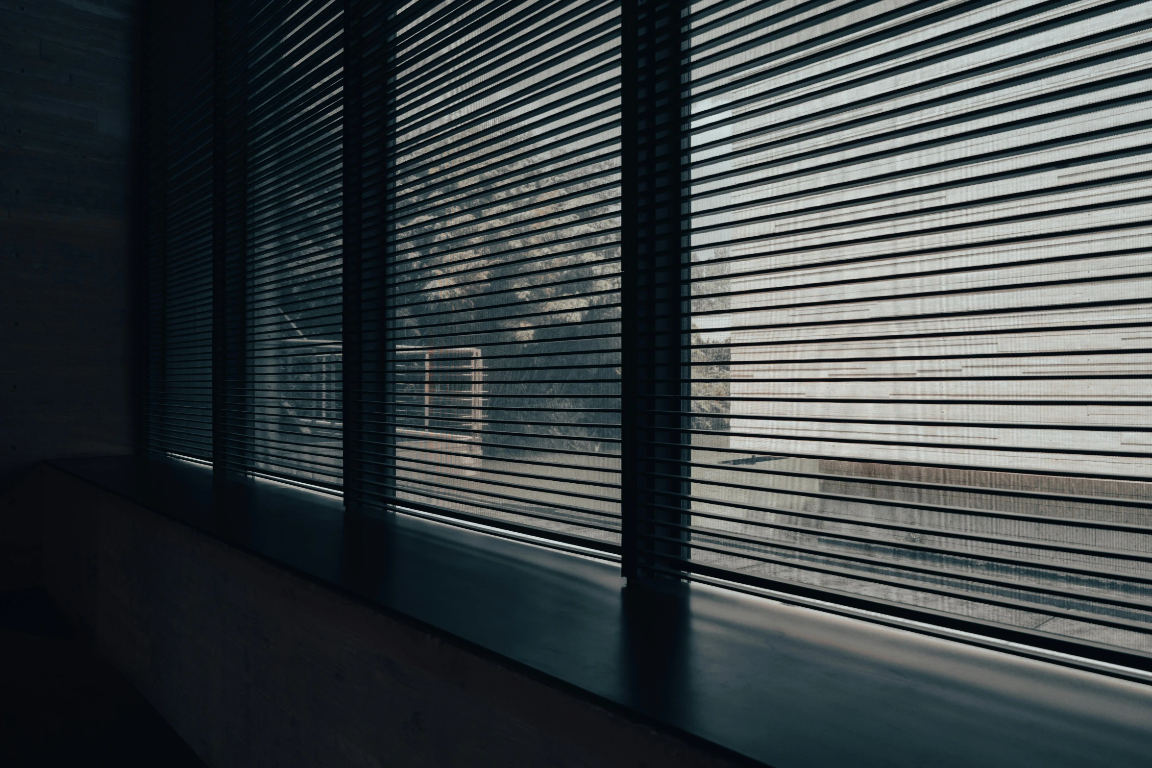 shadows form across the window blinds as the sun goes down