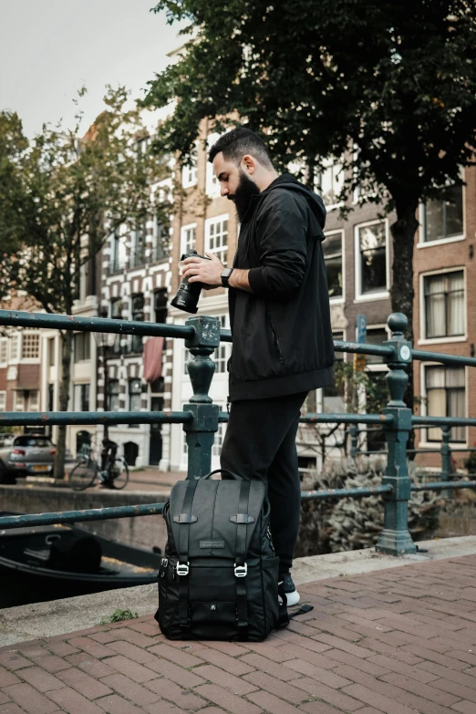 a man holding his cell phone next to his luggage