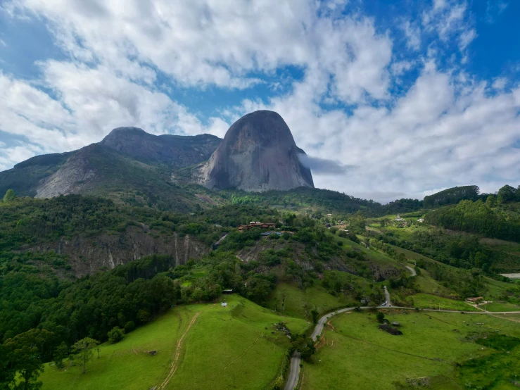 the aerial view of an area with a mountain and a grassy field