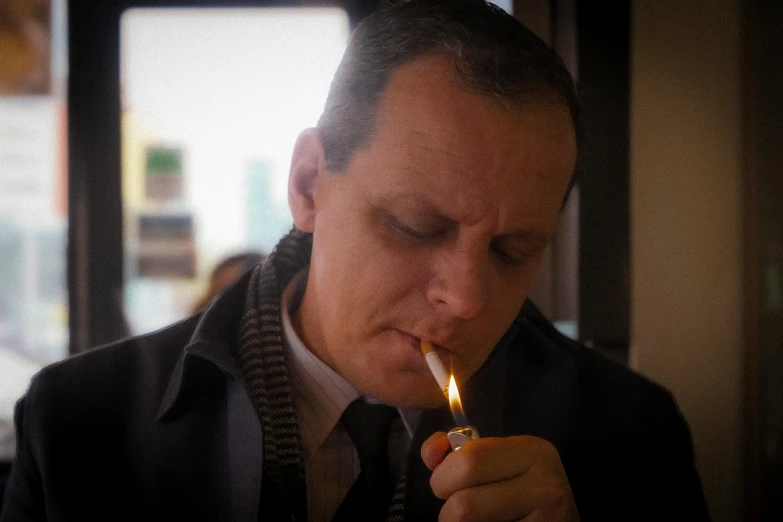 a man in jacket smoking a cigarette while holding up a lighter