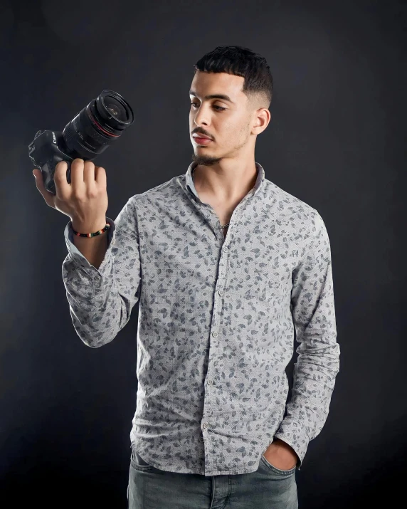 a man holding a camera on a black background