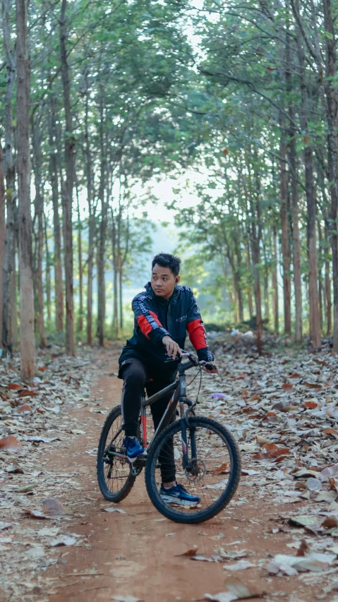 a man riding a bike on a forest path