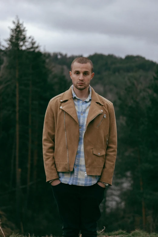 man standing in a field wearing a jacket