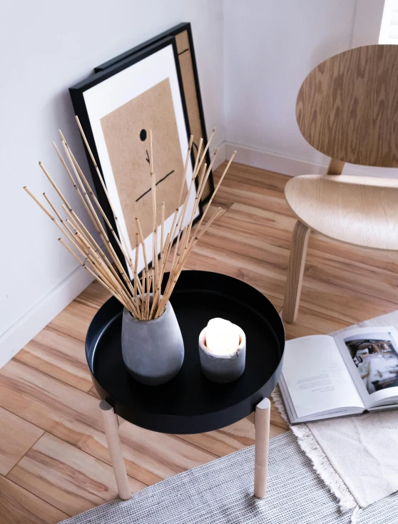 an image of a vase and a candle on a black tray