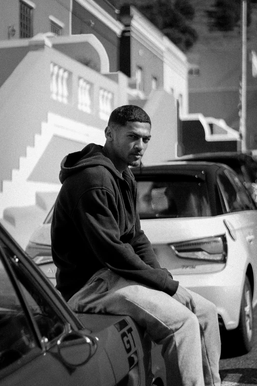 a man sitting outside in front of cars