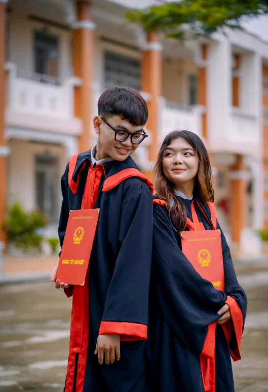 two young men in graduation robes standing on the street