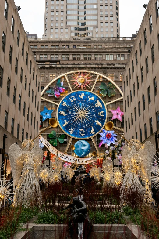 a large display of lights with decorations around it in front of buildings