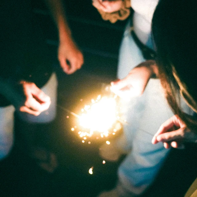 people light up sparklers with bright lights on them