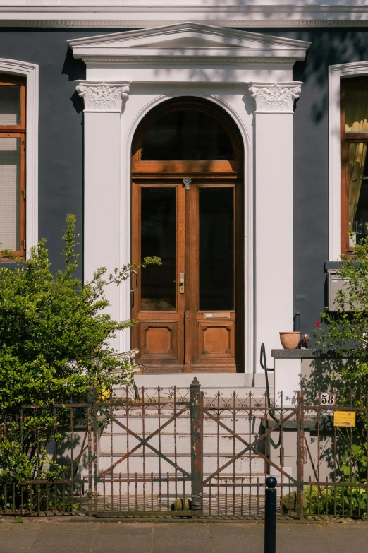 front of an old building with double doors and a fence