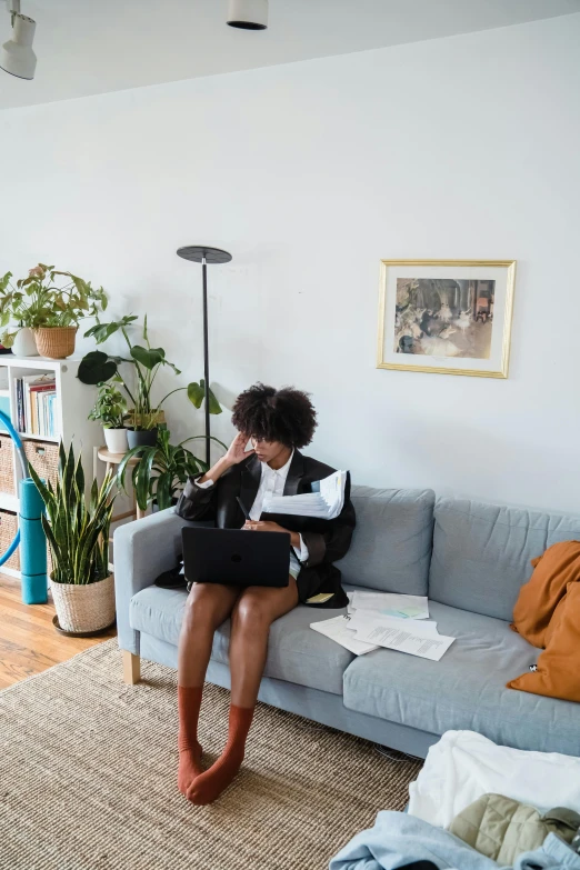 a woman sitting on the couch reading a magazine