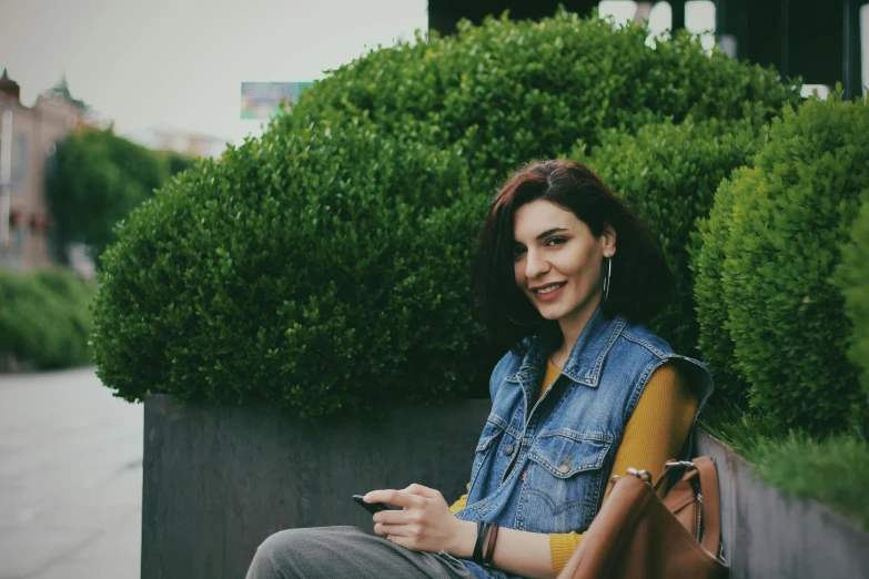 a woman sitting on a bench using a smart phone