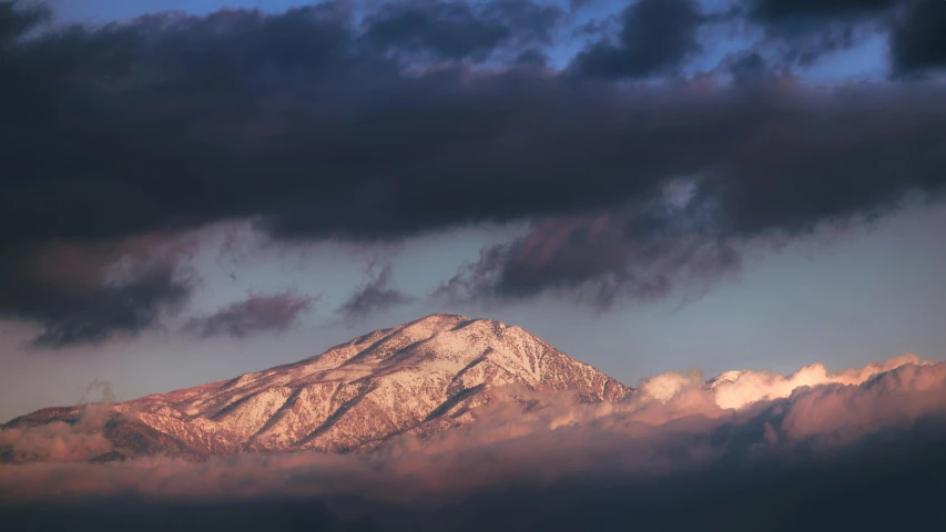 a snowy mountain with a very large amount of clouds