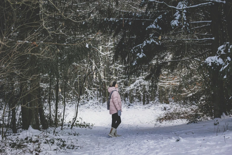 a person standing in the snow near some trees