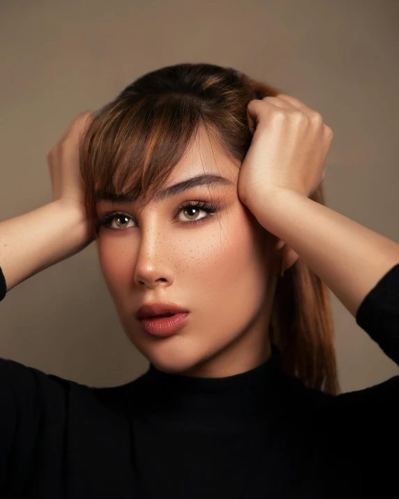 woman with hand on her head standing next to wall