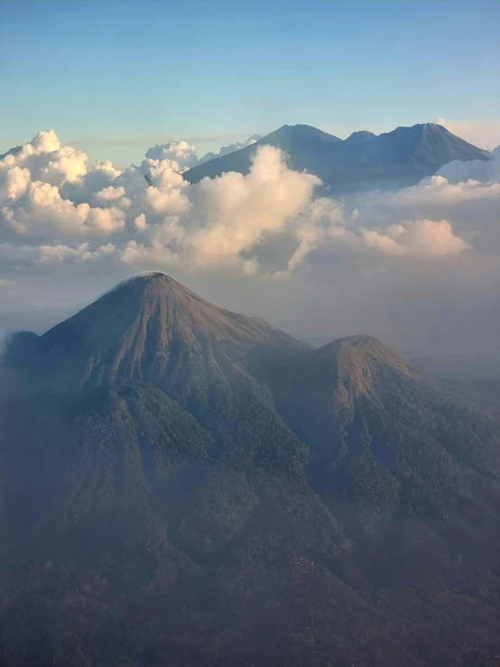 a group of mountain peaks with clouds and a blue sky