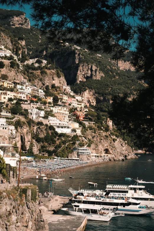 boats are floating near the shore with mountains in the background