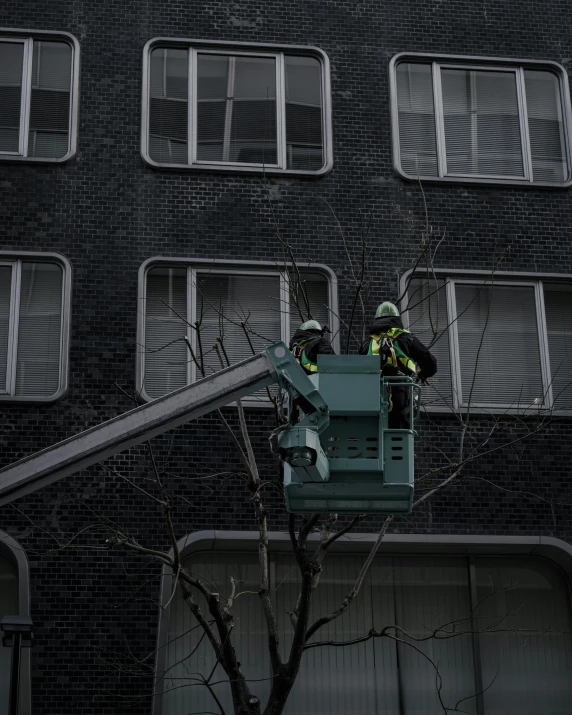 a man on a lift near the tall building