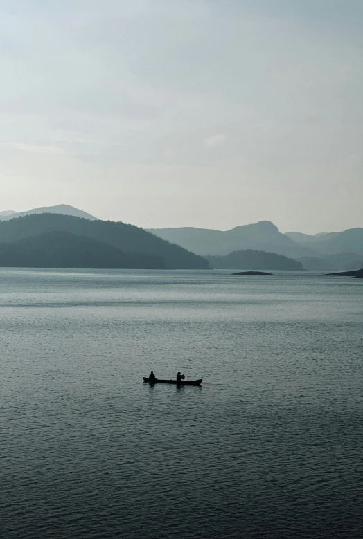 two people in a small boat out on the water