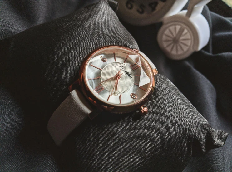 a silver and gold watch on a man's black jacket