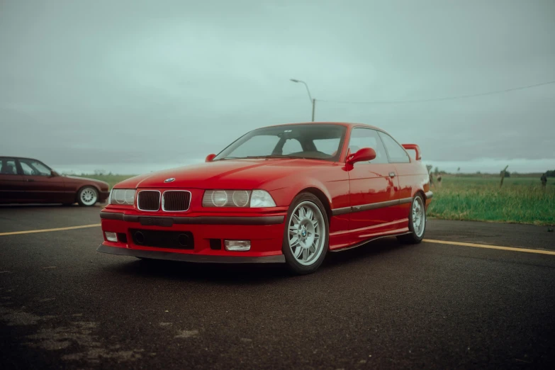 a red bmw coupe is parked in a parking lot