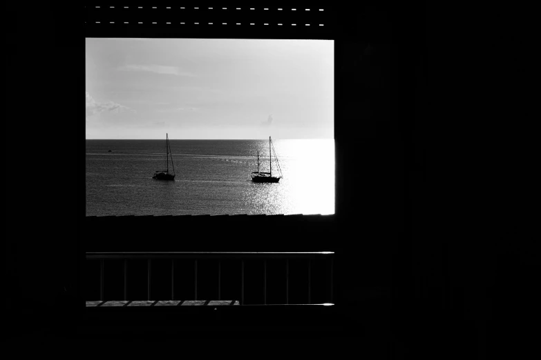 a couple of boats floating on the ocean through a window