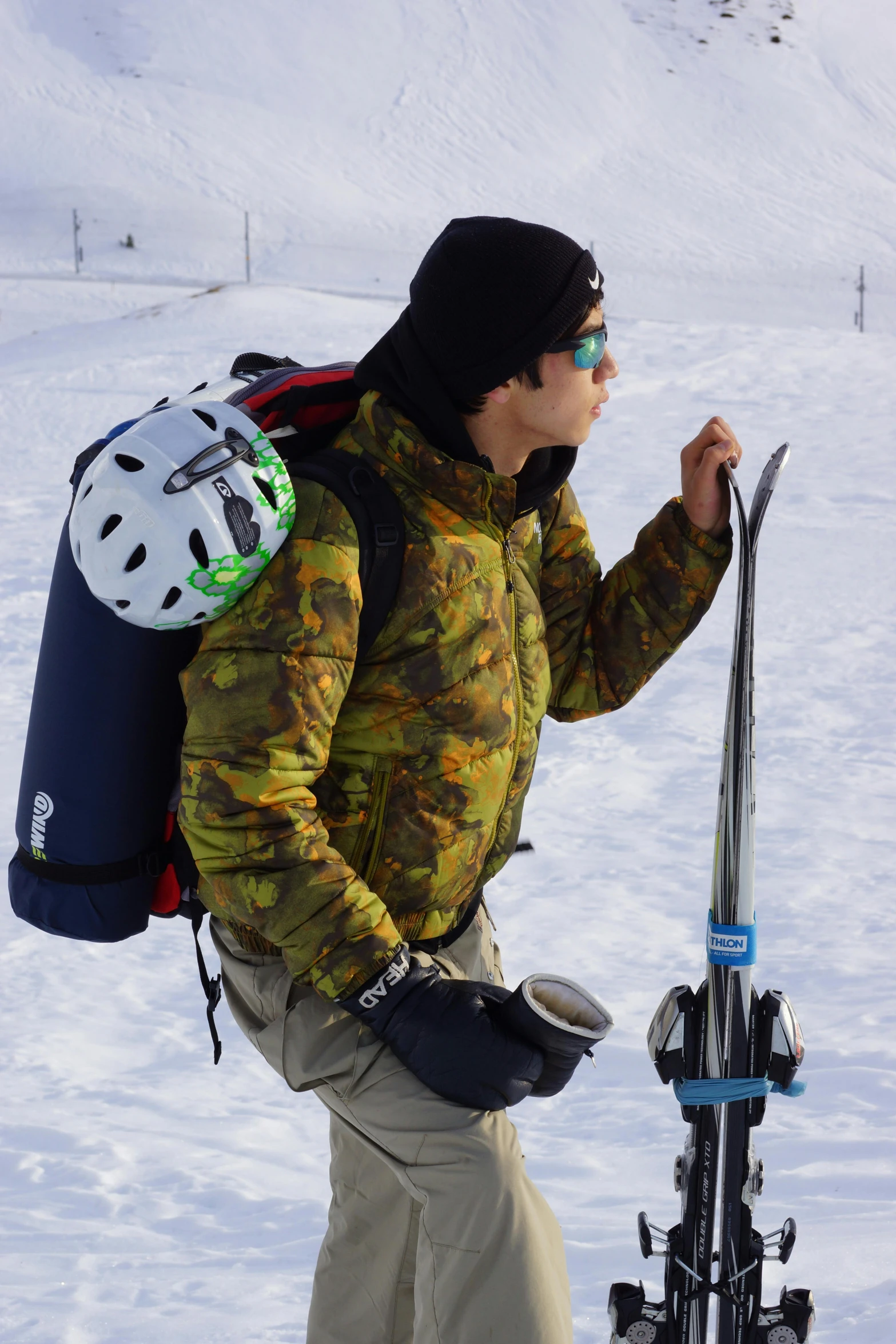 a man walking down the road carrying snowboards