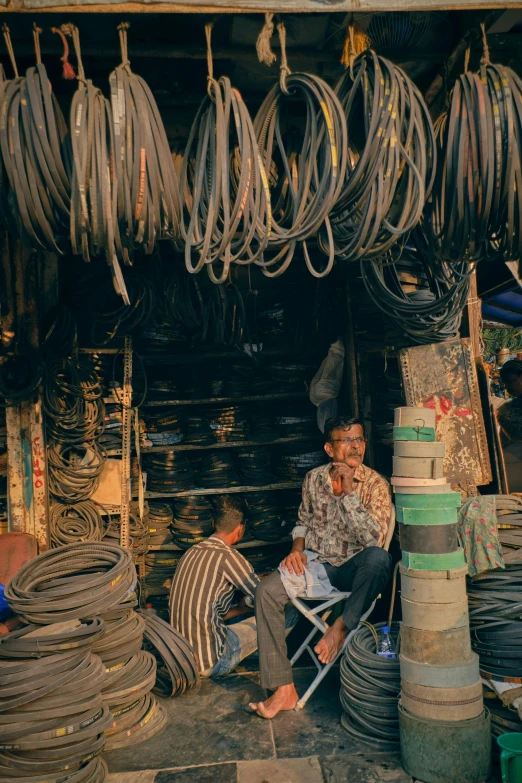 two men sitting in a chair surrounded by wires and wires