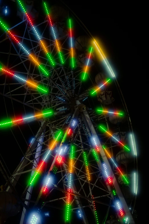 a ferris wheel is seen brightly colored with multiple lights