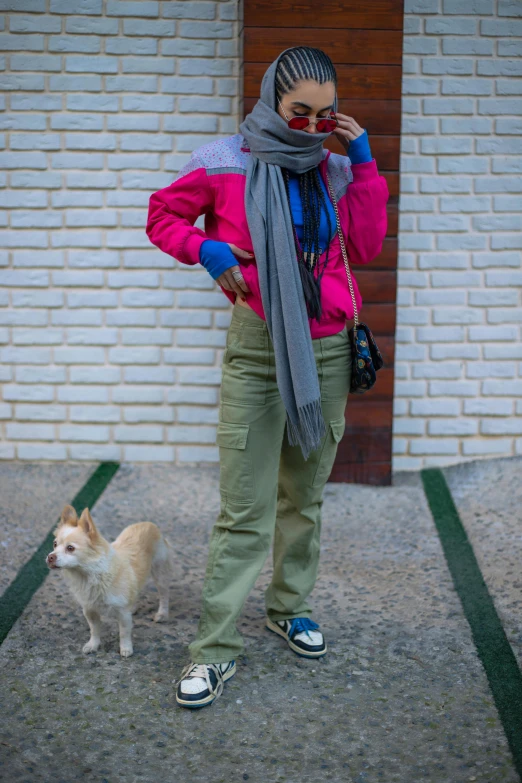 a woman standing next to her dog on the street