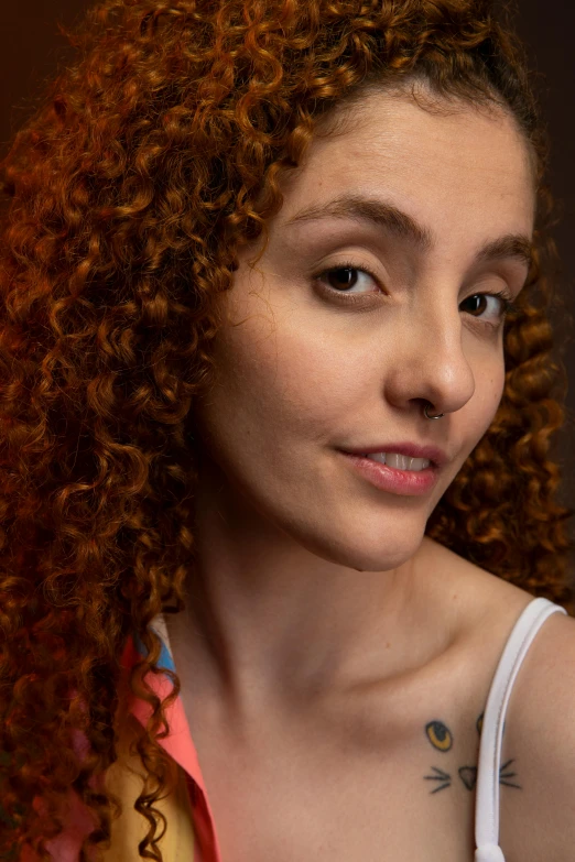 young woman with curly hair, orange shirt and red lipstick