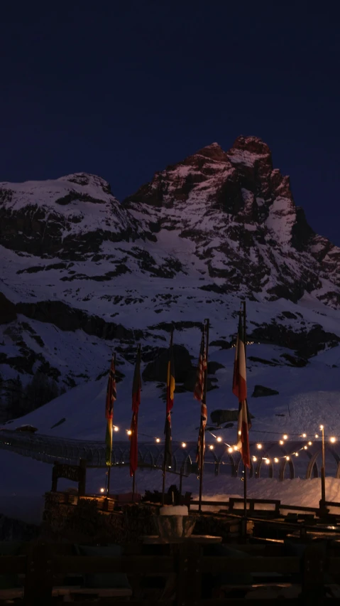 lit tables next to a mountain with flags on it