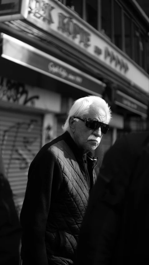 man in a jacket looking at soing on the street