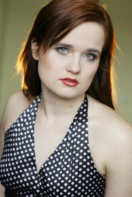 a woman with red hair and blue eyes wearing a dress