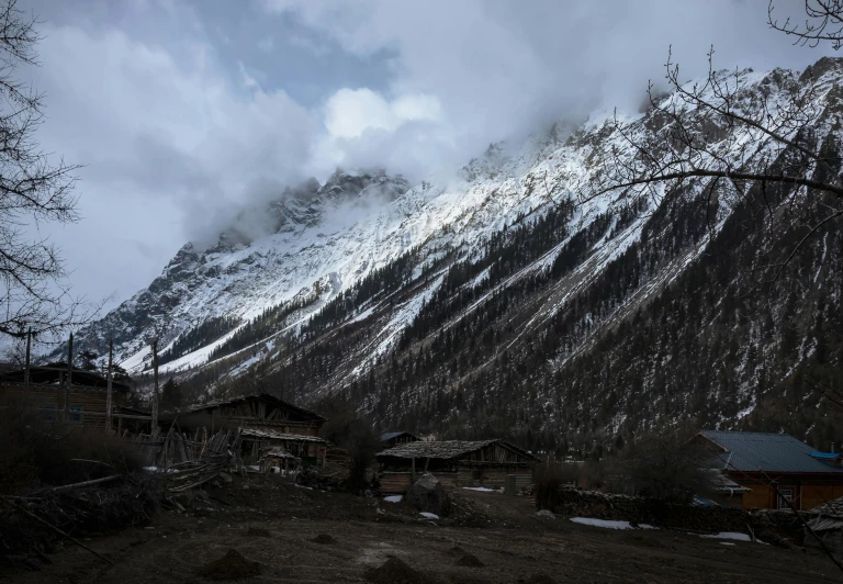 snow covered mountains rise behind small town buildings