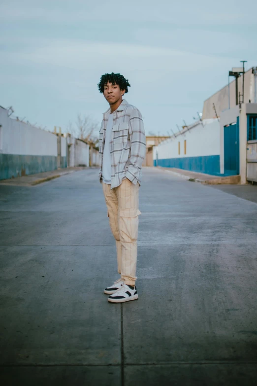 a man with a cap standing on a city street