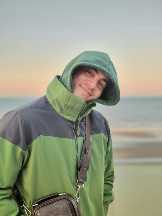 a man standing on the beach with his purse around his waist