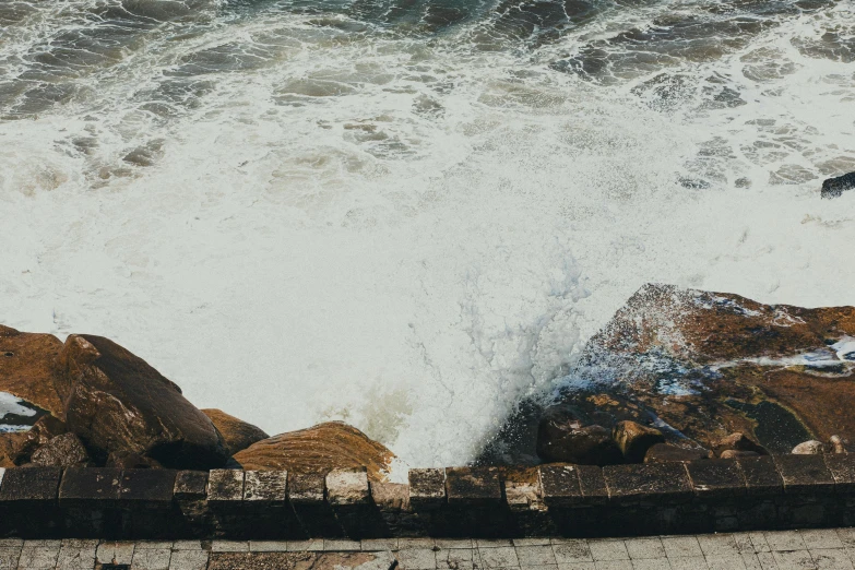 the surf is splashing against the rocks and the water