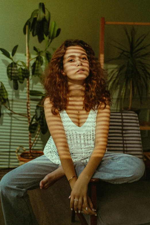 woman with freckles sitting on back of sofa in living room