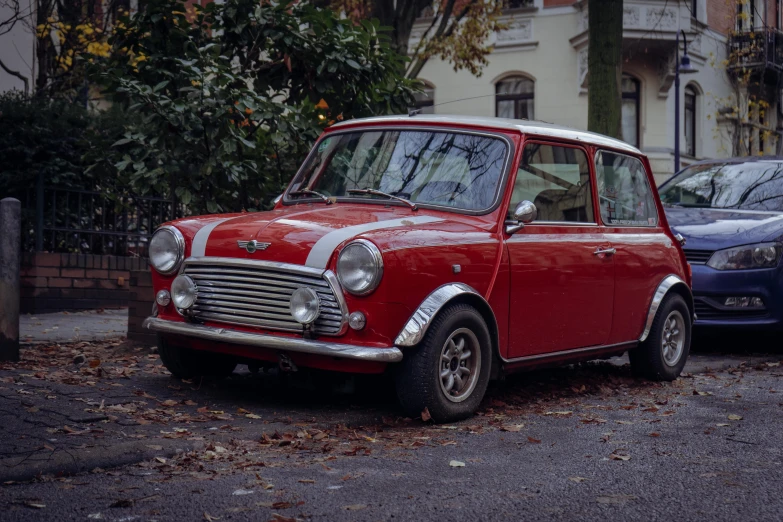 a small red car is parked on the street