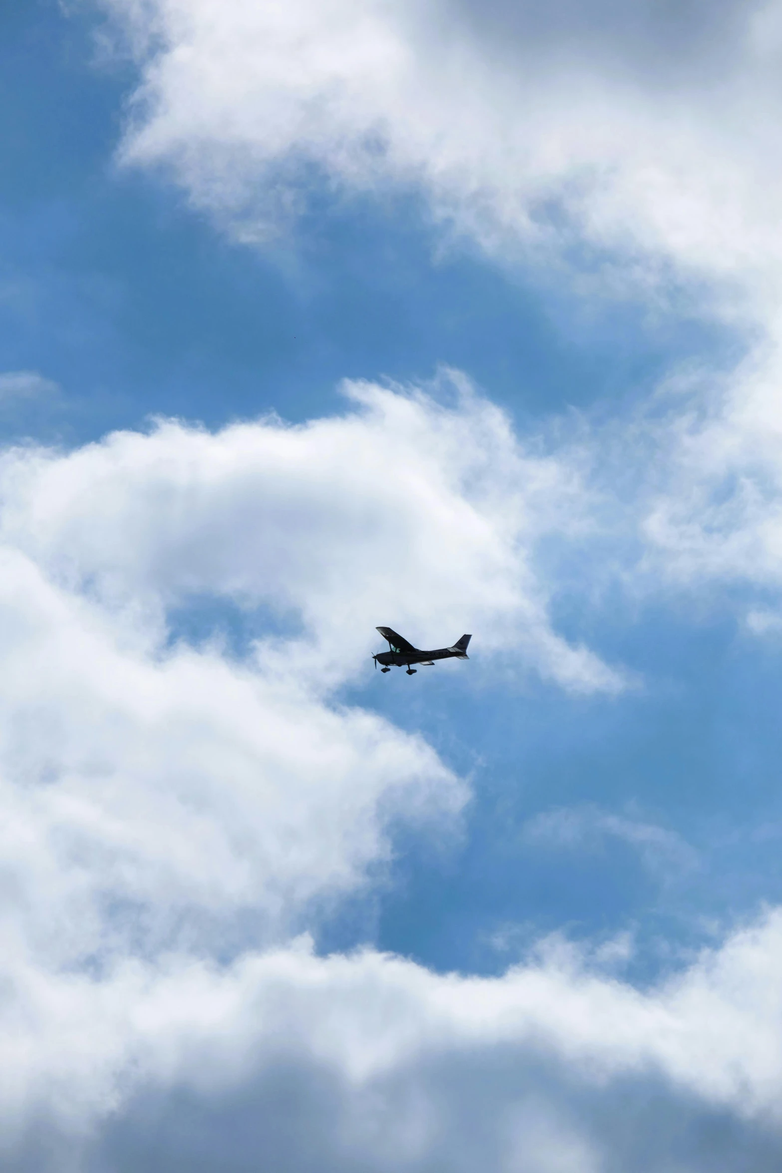 an airplane flying thru the clouds on a clear day