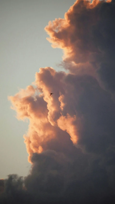 some smoke clouds and a plane in the sky