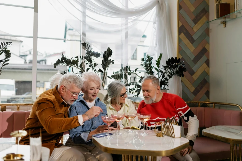 a group of men sit around a table in a restaurant, while a lady points at it