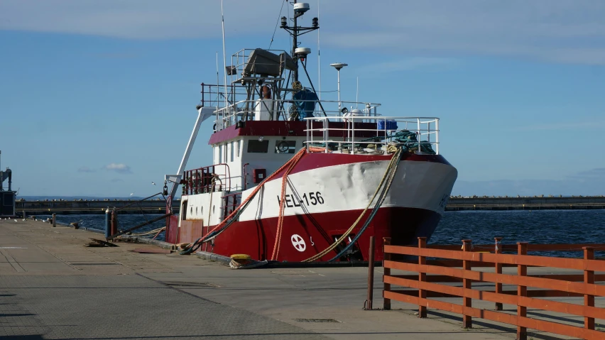 a large red and white boat docked at a pier