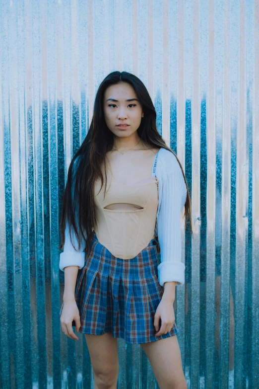 a woman is standing by a large metal wall