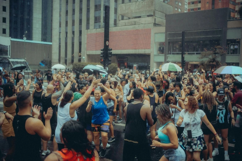 many people have opened their umbrellas and dance at an outdoor gathering